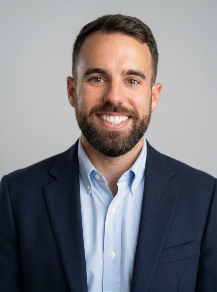 Professional headshot of Coby Weiss, founder of Blackstorm Experts, wearing a navy blazer and light blue shirt against a gray background.